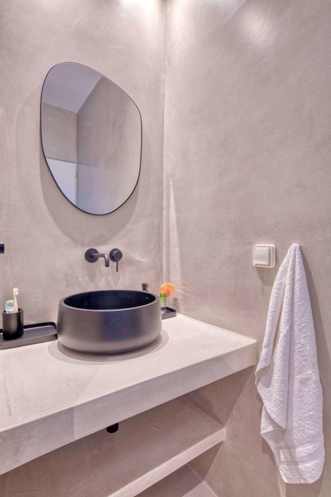 The stone basin with wall-mounted taps and a folded white towel