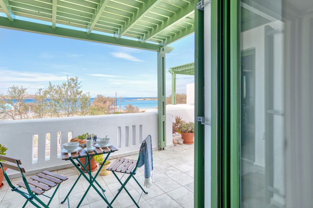 The bedroom door opening directly onto the terrace and the sea beyond