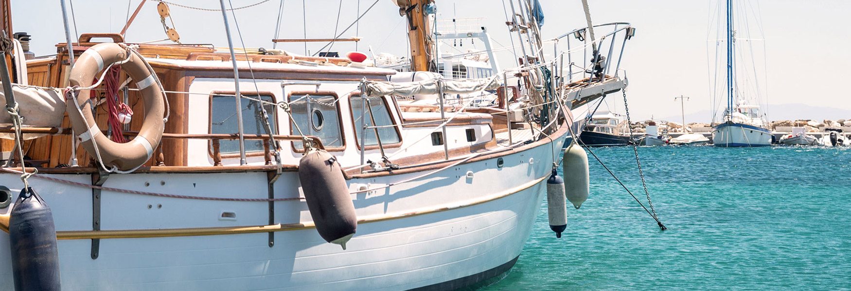 A traditional boat anchored in clear turquoise water off Paros