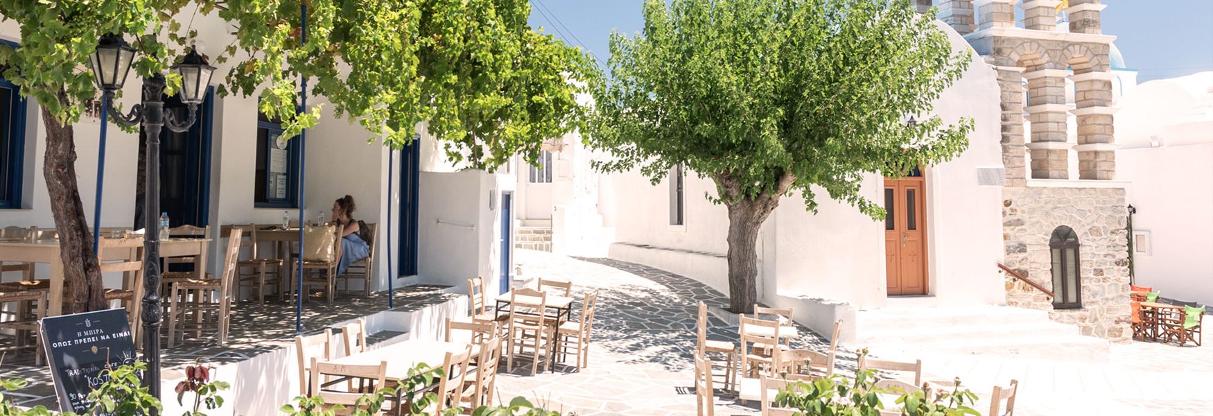 Wooden chairs and tables outside the kafeneion on Kostos square