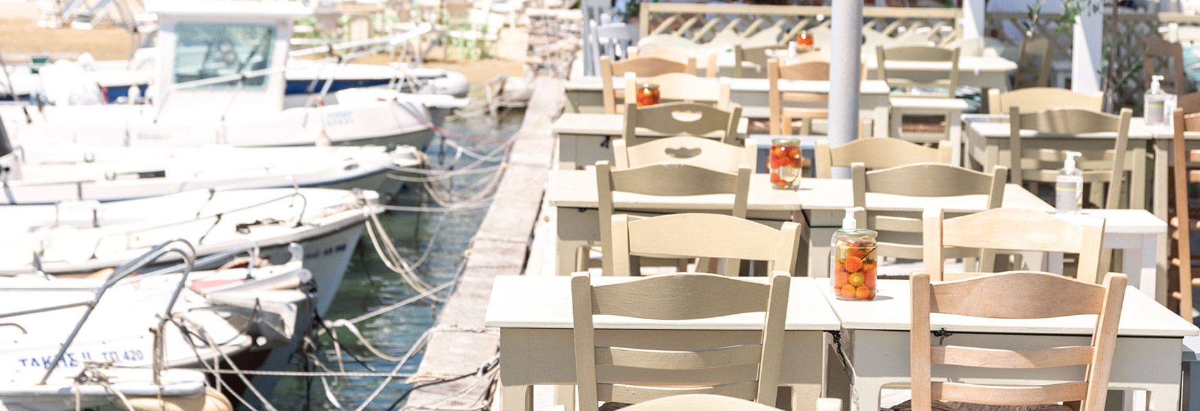 Waterfront tables at Halaris taverna beside the fishing boats in Piso Livadi