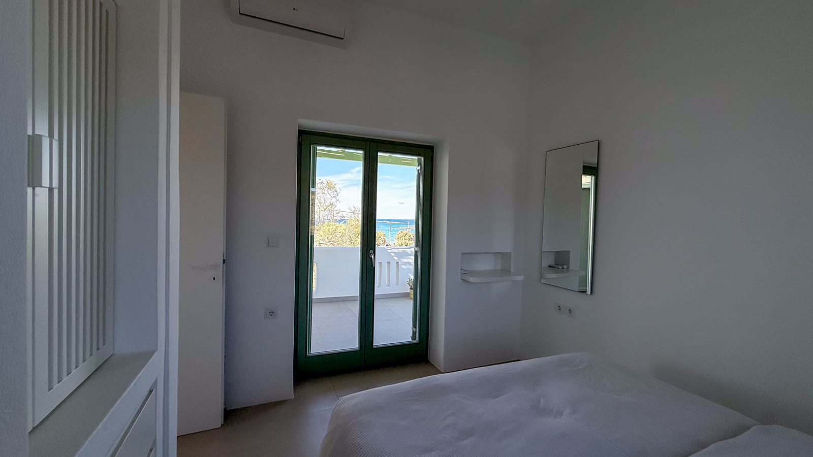 The bedroom terrace doors with the blue Aegean Sea visible beyond