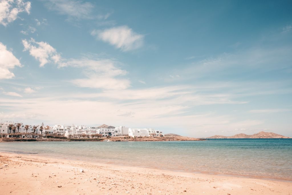The wide sandy beach at Agioi Anargyri with the white houses of Naousa across the bay
