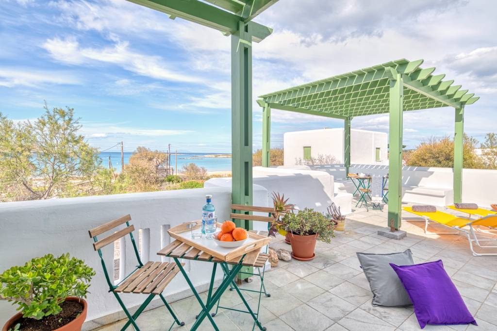 Bistro table and chairs on the terrace with the sea and Naousa in the distance