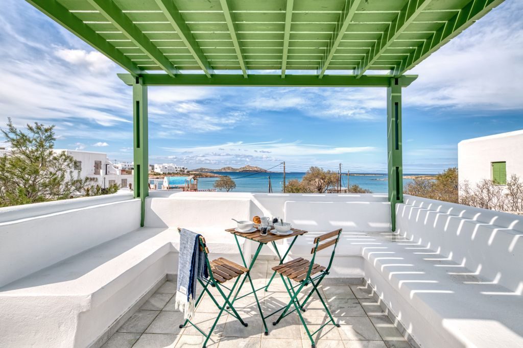 The built-in bench and breakfast table beneath the green pergola